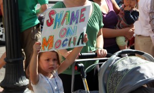 20110925_shame_grossberg A child holds a sign at Friday's protest outside of MOCHA.