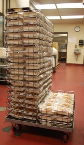 Trays of Pasta w/ Meat Sauce are stacked at the central kitchen.
