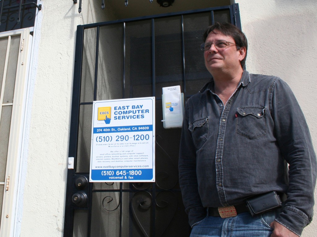 Don Macleay, the Green Party candidate in Oakland's mayoral race, stands in front of the building he owns on 40th Street that houses his computer business and his apartment.