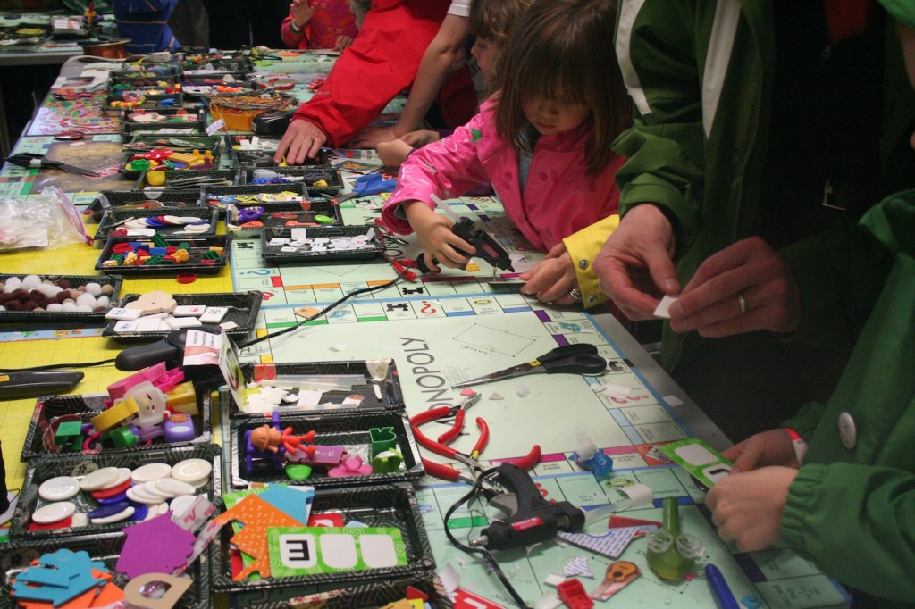 Attendees at the 2010 East Bay Maker Faire create name badges at an arts & craft table.
