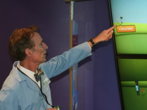 Bill Nye, known for his children's TV show in the 90s, points out 'Moe,' his Climate Lab avatar at the new exhibit named for him at the Chabot Space and Science Center.
