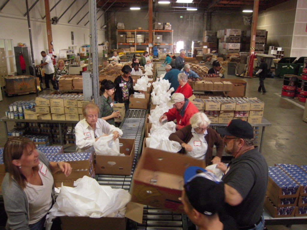 Food bank volunteers pack meals for children with cereal, milk, beans and rice. Photo courtesy of the Alameda County Community Food Bank.