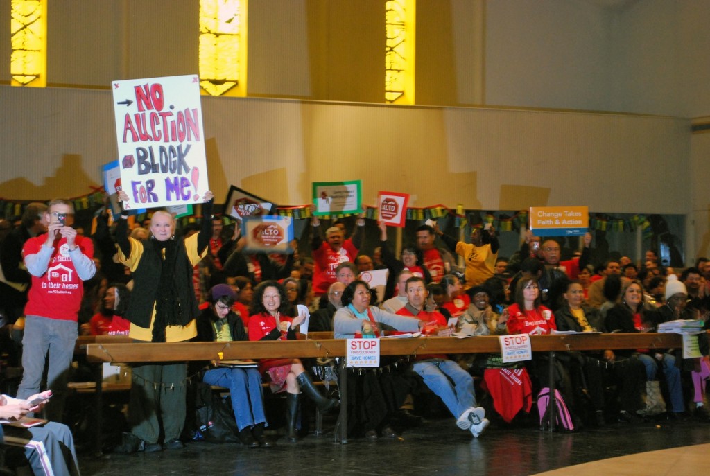 Community members held signs and applauded the politicians who promised their support for a senate bill requiring banks to consider a loan modification for any homeowner who applied for one.