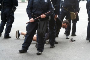 20111025_schell_occupy2 A man, who identified himself as Michael Stoker, is lifted off the ground by police officers after a small scuffle in which his face was cut. Photo by Brittany Schell.