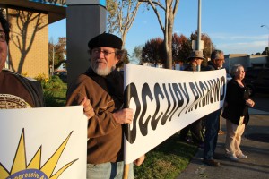 Juan Reardon of Richmond stands in front of Chase Bank on San Pablo Ave. Eleven protesters started their march to Oakland city center at 8:30 a.m. Wed. (photo by: Maggie Beidelman)
