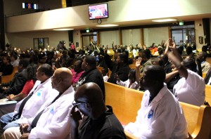 Community members raise their hands to indicate that they have personally been affected by gun violence.