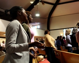 Inside Allen Temple Baptist Church, community members sing along to hymns as part of Thursday's gathering.
