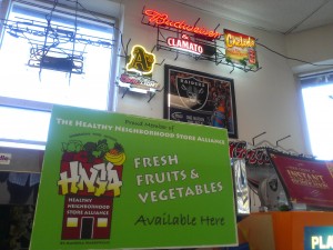 A Healthy Neighborhood Stores Alliance banner hangs in Bottles Liquor store in West Oakland, indicating the store has pesticide-free produce for sale.