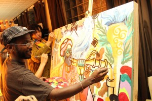 Local artists "Black Diamonds Shining Art Collective" completes a painting auctioned off Thursday night.