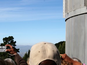 The shuttle itself is barely visible, low on the horizon between trees.