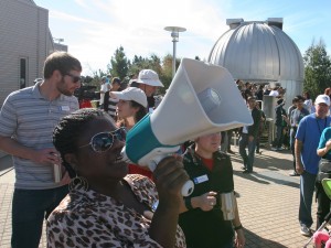 Community Affairs Manager Lyisha Johnson gives updates to the crowd via megaphone.