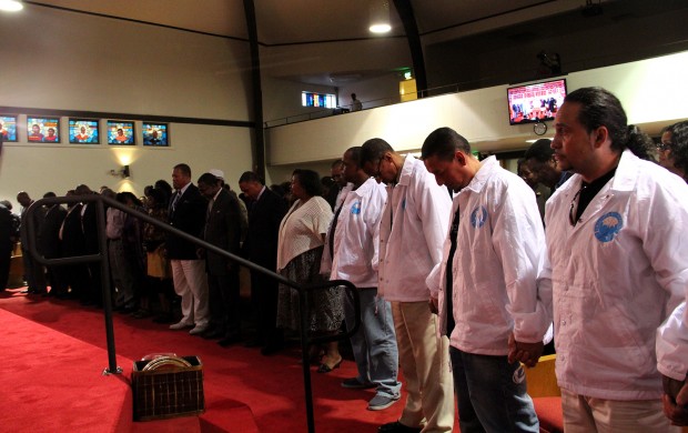Community members bow their heads and pray in Allen Temple Baptist Church last month as religious leaders ask for more involvement in reducing street violence and rally for Ceasefire.