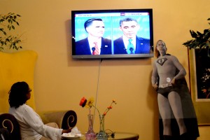 An Obama superhero cutout stands beside the televised debate. Photo by Nausheen Husain.