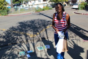 Volunteer Lasheta Jackson stands on a corner in West Oakland, reminding residents passing by to vote.