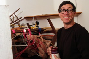 Kevin Clarke, the co-curator and inhabitant of MacArthur B Arthur, poses beside an installation made from the contents of his work space.