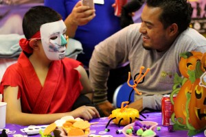 Boy and his father tries on a Halloween mask