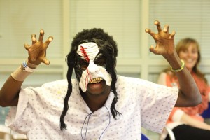 A patient poses with a mask at Children's Hospital's Halloween party.