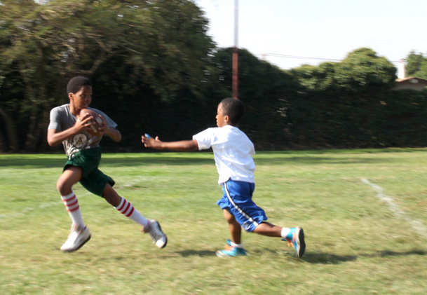 Two kids playing flag football.
