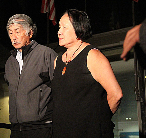 Mayor Jean Quan (right) listens as the announcement to end the BART strike is made Monday night. Photo by Jenny Chaussee.