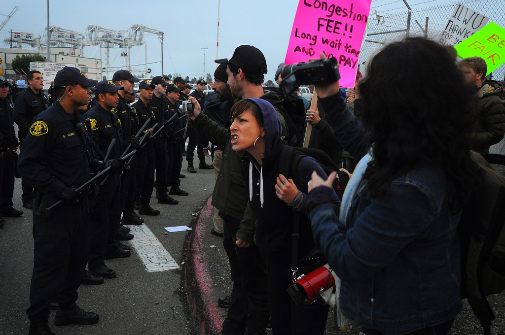 A photo of an activist screaming at the police.