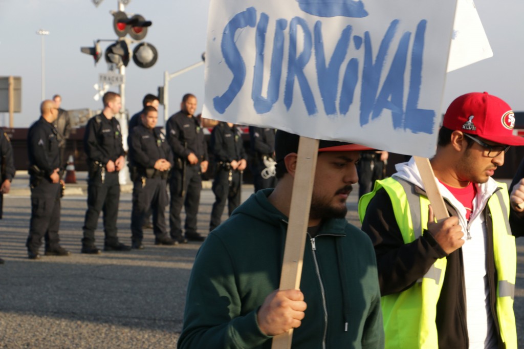 A photo of picketers with police in teh background.