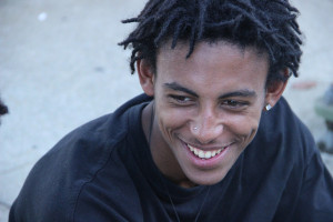 Jay Kaly, 17, sits on the sidewalk in-between shows. Photo by Melina Tupa