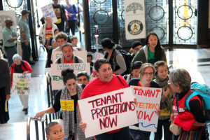 Supporters of the Tenant Protection Ordinance march inside Oakland City Hall.