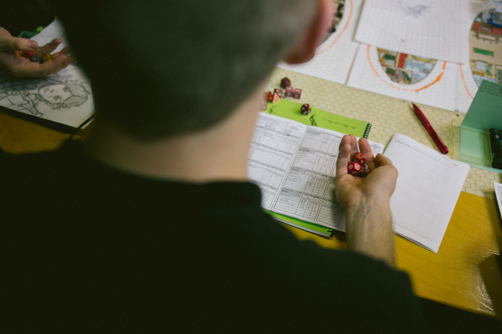 A player prepares to roll dice at an alum-only Abantey night.