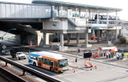 A soon-to-be extinct AirBART shuttle bus drives past the new "BART to OAK" station about a week before its opening.
