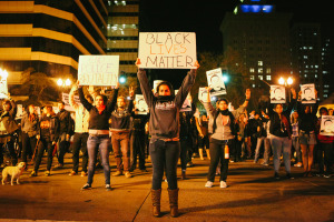 Protesters hold up signs at the intersection of 14th and Broadway in downtown Oakland following the release of the Ferguson grand jury verdict. November 24, 2014. (Photo by Bonnie Chan)