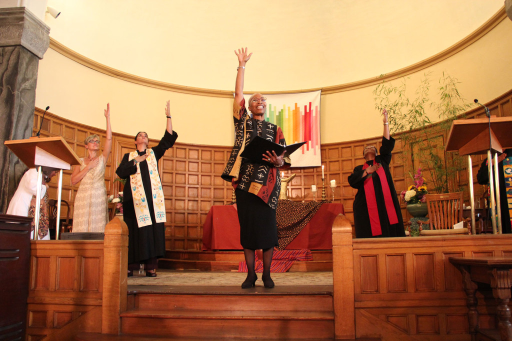 Reverend Jacqueline Duhart (center) is leading a praise with the First Unitarian Church of Oakland's congregation during her installation on October 5, 2014.