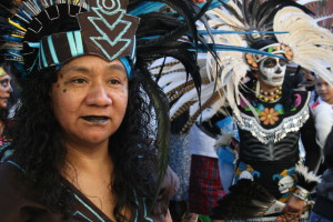 Groups wearing face paint and fierce costumes dance at the sacred celebration of Day of the Dead.