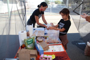Mamacitas Cafe co-founder Renee Geesler and 8-year-old Kiana Tondre prepare donut kebabs.