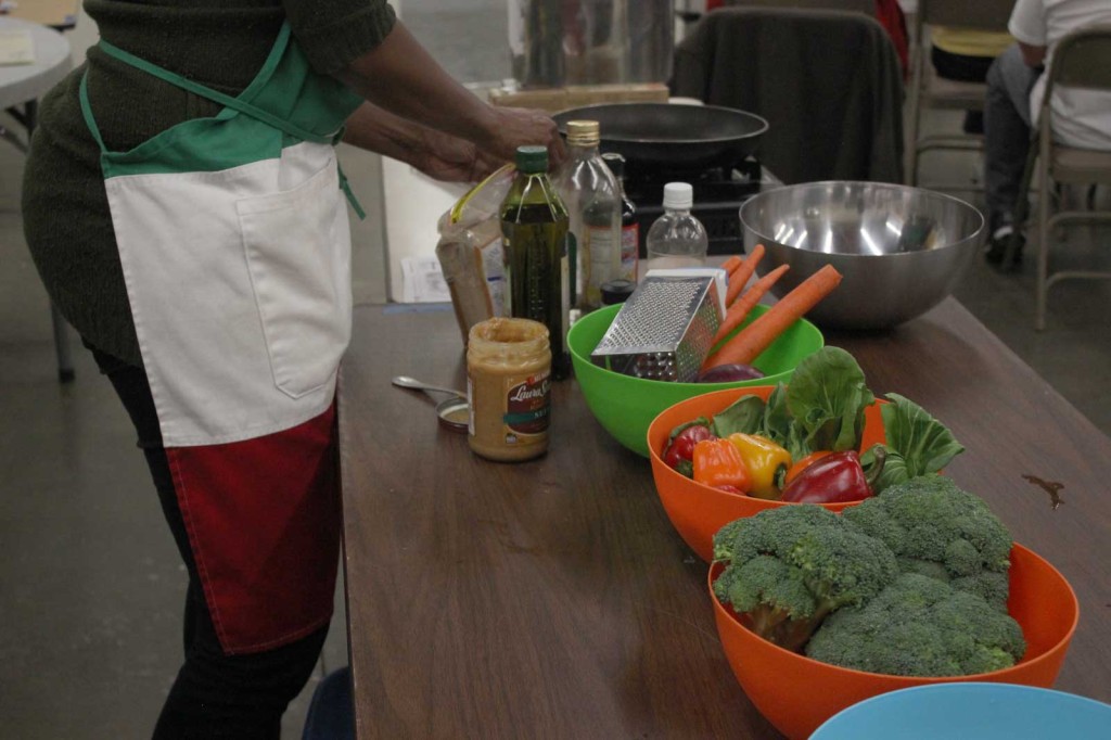 HuNia Bradley assembles ingredients for the Cooking Matters participants to put together a noodle salad at Alameda Point Collaborative on Nov. 13. Photo by Vanessa Reyes Walker.