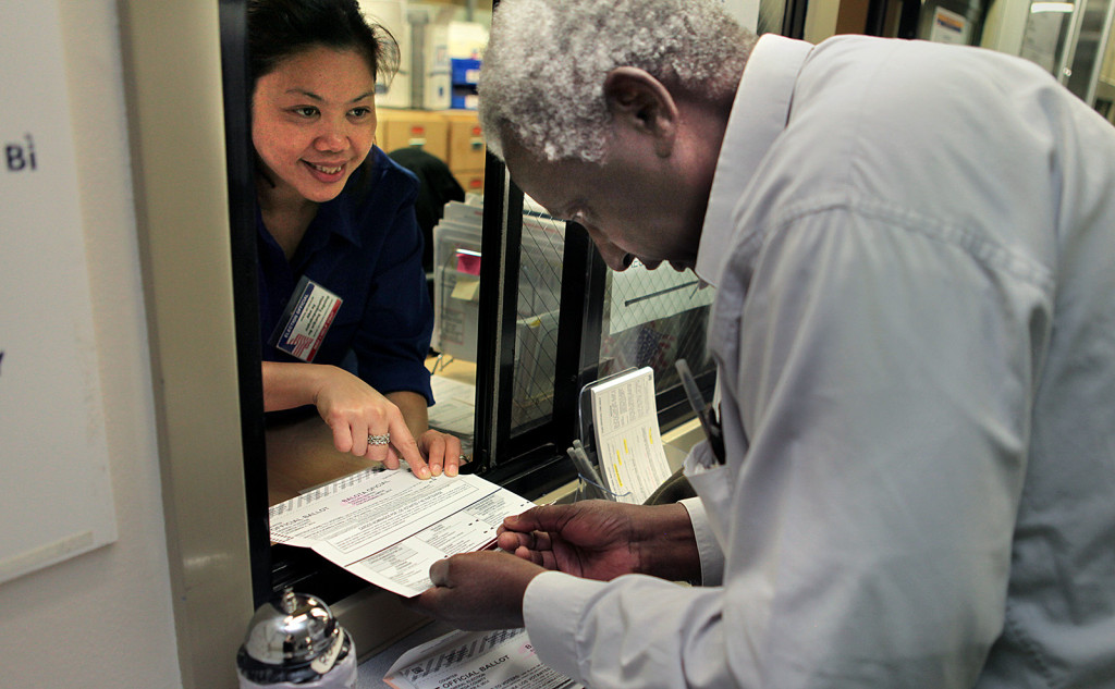 Election official Maria Cabahug, left, gives instructions to Ben Oigara, who voted for the first time as a U.S. citizen at the Alameda County Registrar of Voters Office today. Oigara came to the States from Kenya in 2001. Photo by Deana Mitchell.