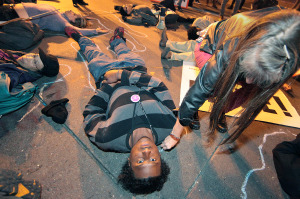 Pattie Rich, right, draws a chalk outline around protester Christopher Jackson, as a group lay in the street at the corner of Broadway and 14th in downtown Oakland, Nov. 24, 2014.