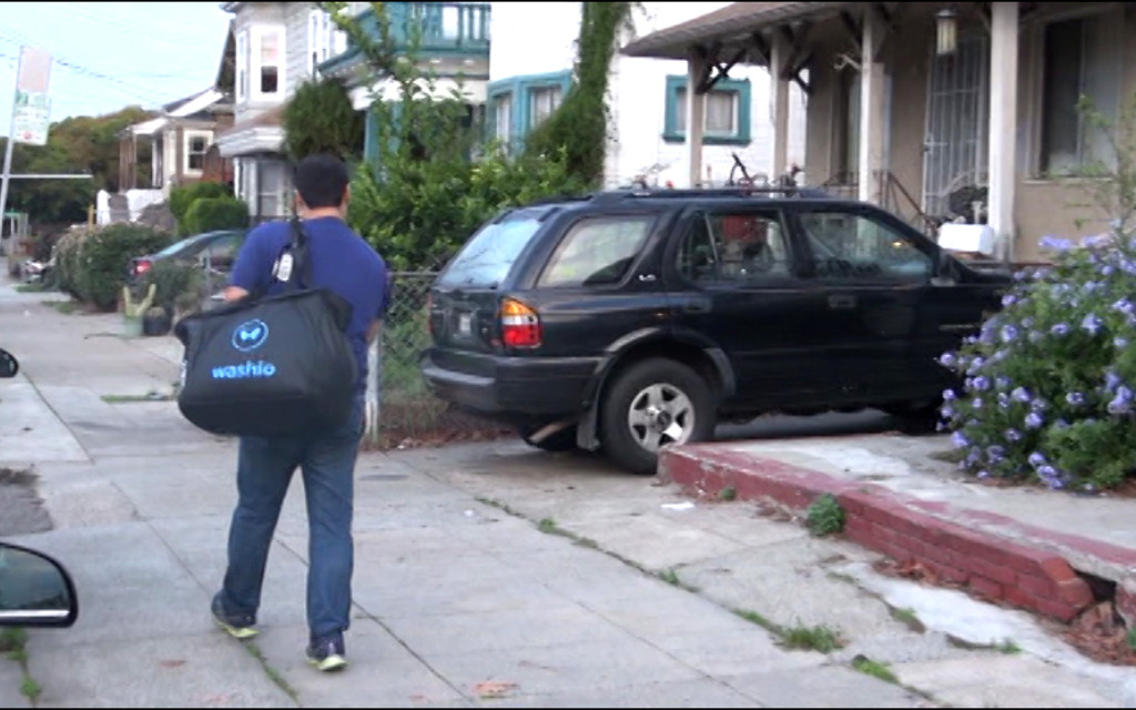 Mehdi Shokouhi, a Washio driver, delivers laundry to an Oakland customer who ordered the service through an app.