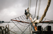 Becca Buckler, Hawaiian Chieftain's boatswain, working onboard as the ship sails out of Jack London Square towards the bay. (Photo by Bonnie Chan)