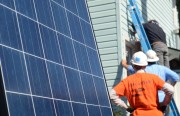 Volunteers with the non-profit Grid Alternatives install solar panels in Atchison Village, Richmond.