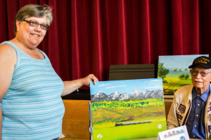 Gene sells his train painting for $15 to a customer from Oakland. Photo By Alsanosi Adam