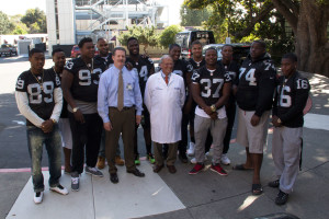 Dr. Bertram Lubin, CEO of Bennioff Childrens’ Hospital Oakland, poses with the Oakland Raiders’ Rookie Club after briefing the players in preparation for their visit.