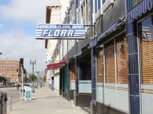 Owners of Flora, an up-scale restaurant on Telegraph Ave. and 19th St., have cut back on employee perks to cover increased payroll costs.
