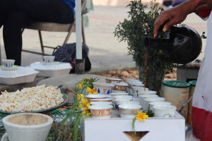 A lady serves buna, traditional Ethiopian coffee, typically accompanied with a small serving of pop corn.