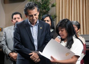 Noel Gallo (District 5) lets, Arlett Hernandez, a student at American Indian Public High School, read the resolution recognizing National Hispanic Heritage Month. Photo by Mariela Patron.