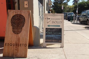 Signs for Doughnut Dolly and Esqueleto, two of the businesses located in Temescal Alley.