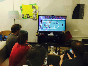 Four gamers huddled around a television playing "Super Slam Dunk Touchdown" at Reddit HQ.