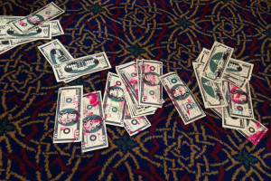 Protesters threw fake money covered in fake blood from the balcony at Tuesday's Oakland City Council meeting, calling for the council to reject a U.S. Department of Justice grant tied to hiring 15 new police officers.