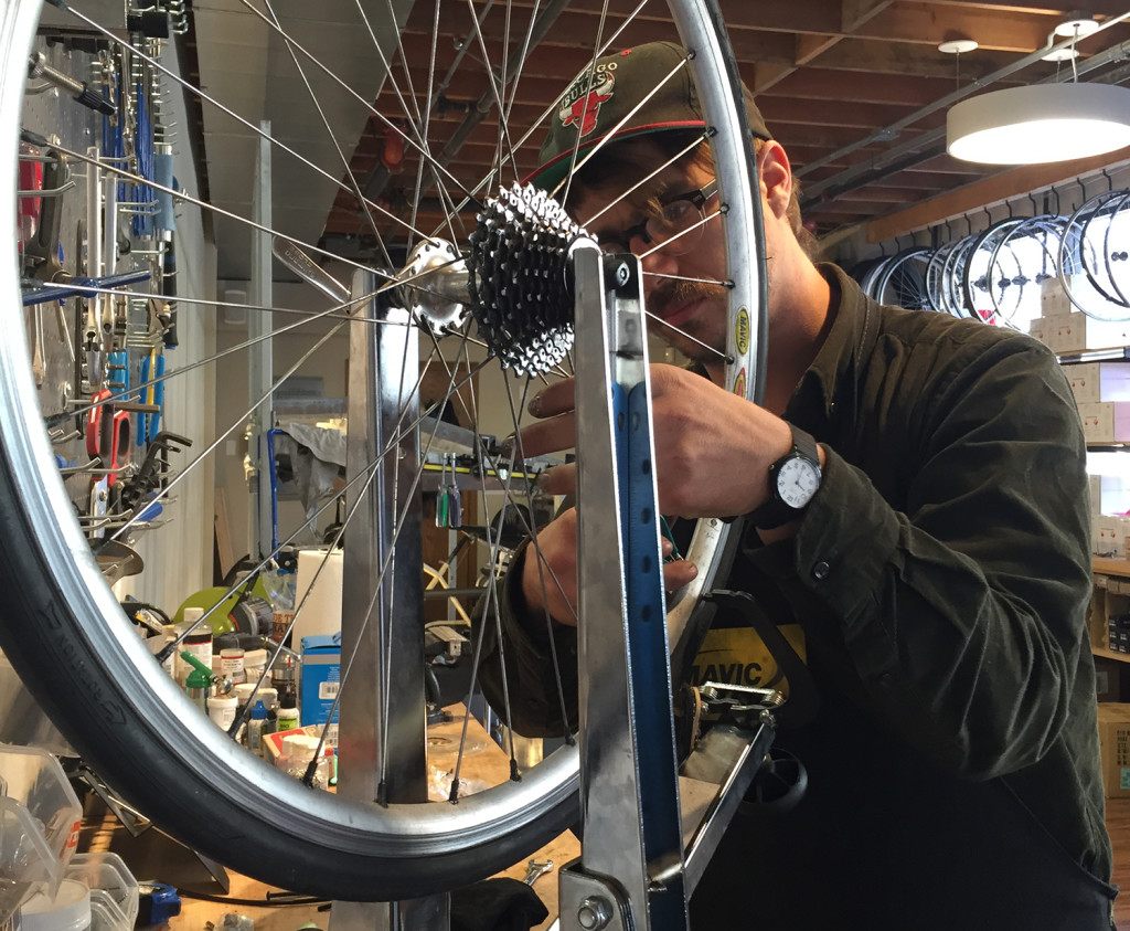 Thomas Denesha is repairing a customer's bike at Uptown 19th Street BART Bike Station
