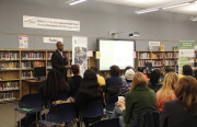 Superintendent Antwan Wilson presents to a group of parents, teachers and administrators at the West Oakland Middle School library.