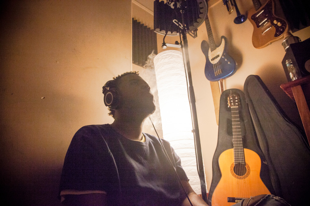 Dayvid Michael, a 23-year-old rap artist from Oakland, in the midst of a recording session at his home studio in Central East Oakland. Michael got into music through playing guitar.